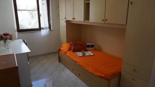 a bedroom with a bed with an orange bedvisor at Appartamento Sanaccara by Holiday World in Alghero