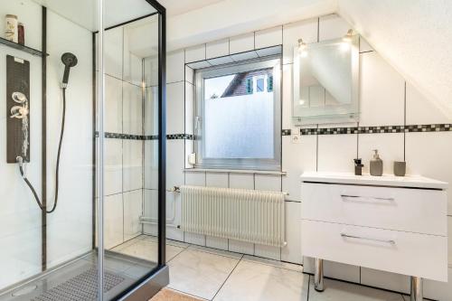 y baño con ducha y lavamanos. en Ferienhaus Burghalde mit Sauna, en Alpirsbach