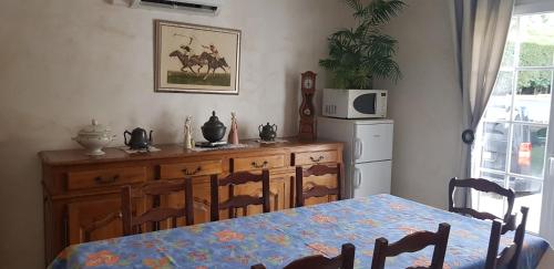 une salle à manger avec une table et des chaises et un micro-ondes dans l'établissement Chambre d hotes, à Montlignon