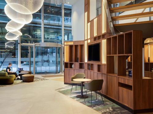 a lobby with a table and chairs in a building at Novotel London Paddington in London