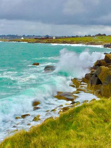 une masse d'eau avec des vagues s'écrasant sur les rochers dans l'établissement Maison LA CALE vue mer à 300 m de la plage, à Plouarzel