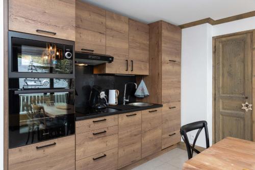 eine Küche mit Holzschränken und einem Herd mit Backofen in der Unterkunft les 7 laux immobilier chalet E in Prapoutel