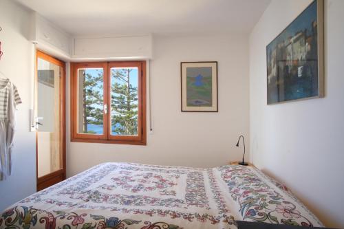 1 dormitorio con cama y ventana en Profumo di Mare, en Cipressa