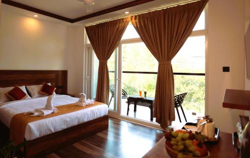 蒙納的住宿－Elenji Revive Resort，一间卧室设有一张床和一个大窗户