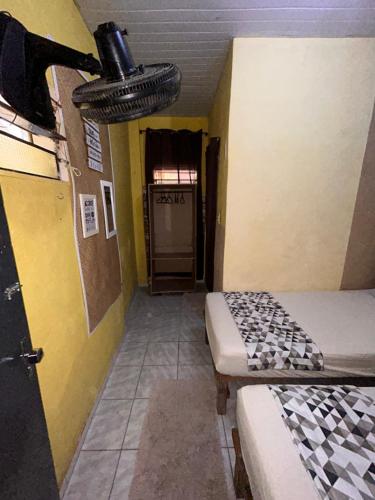 um quarto com duas camas e um corredor com uma porta em Casa du CéSaR em Fortaleza