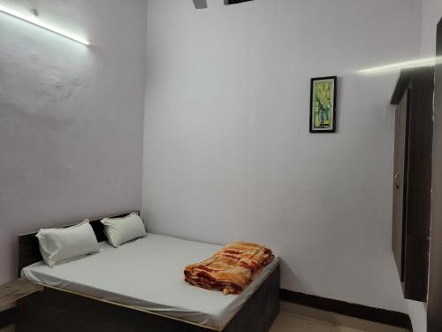 Ce lit se trouve dans un dortoir doté d'un mur blanc. dans l'établissement Hotel Samman, à Siwān