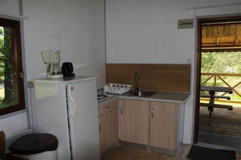 a kitchen with a white refrigerator and a sink at Au bois de Calais in Corrèze