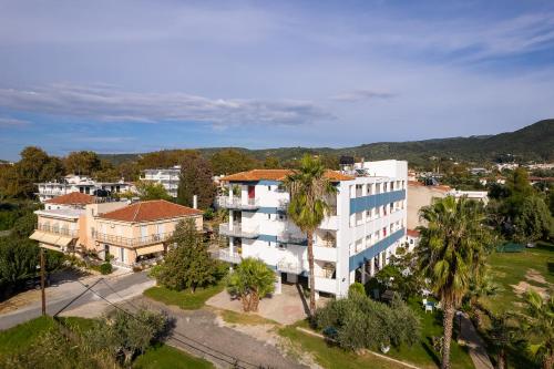 - une vue sur un bâtiment blanc avec des palmiers dans l'établissement Zoe Seaside, à Loutra Edipsou