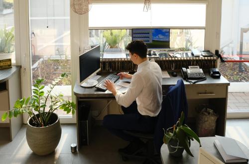 a man sitting at a desk with a computer at Hotel Motel 2000 in Trezzano sul Naviglio