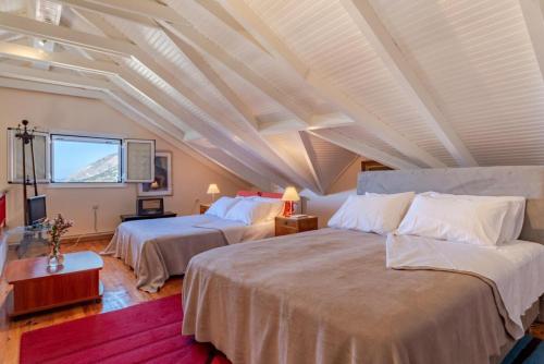 two beds in a room with a white ceiling at Art Gallery Villa Kefalonia Sea View and Breakfast in Kardhakáta