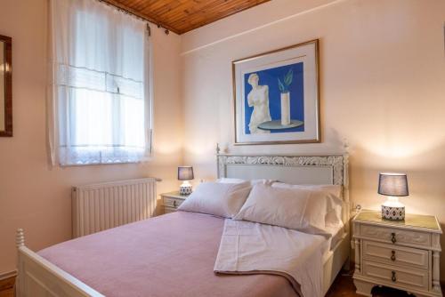 a bedroom with a bed and two night stands with lamps at Art Gallery Villa Kefalonia Sea View and Breakfast in Kardhakáta