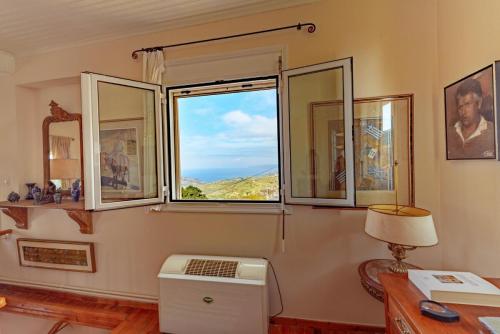 a room with three windows and a table with a lamp at Art Gallery Villa Kefalonia Sea View and Breakfast in Kardhakáta