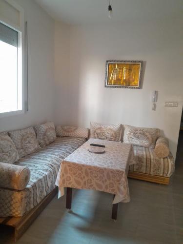 a living room with a couch and a table at Alhoceima Ville Appartement in Al Hoceïma