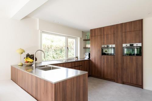 a kitchen with wooden cabinets and a sink and a window at Bunker 155 in Ostend