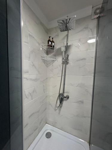 a bathroom with a shower with two people standing on a shelf at Уютная, светлая квартира-студия в районе Акмешит in Qyzylorda