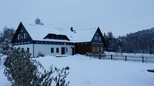 a house covered in snow in a field at Doubický Venkov in Doubice