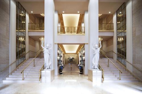 two statues in the lobby of a building with stairs at Waldorf Astoria New York in New York