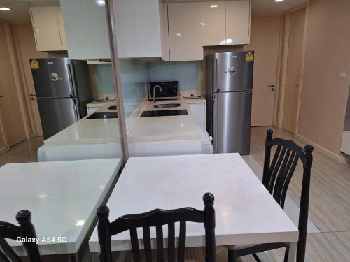 a kitchen with a table and a refrigerator at LIV@5 Condominium in Makkasan