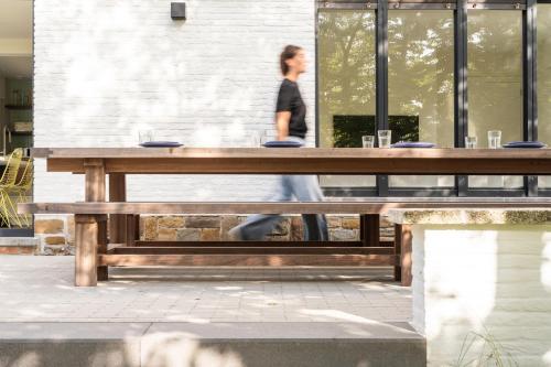 a woman walking past a wooden picnic table at Bunker 155 in Ostend