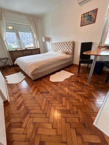 a bedroom with a bed and a wooden floor at Cozy with parking in Zemun