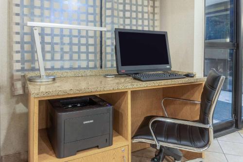 a desk with a computer and a printer and a chair at La Quinta by Wyndham Chicago Gurnee in Gurnee
