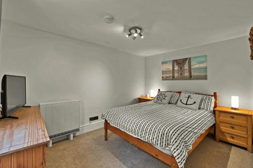 Finest Retreats - Porthole Cottage في ميفاغيسي: غرفة نوم فيها سرير وتلفزيون