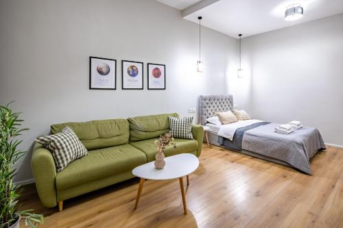 a living room with a green couch and a bed at Your sweet home in Lviv Near Opera in Lviv