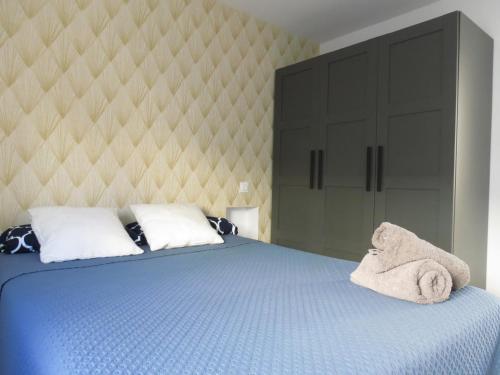 Un dormitorio con una cama azul con toallas. en Apartamento JARDIN DELUZ, con Wifi y Parking privado gratis, en Santander