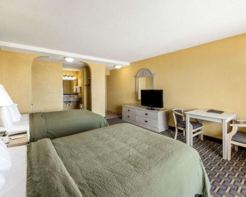 a hotel room with a bed and a desk at Quality Inn & Suites Corpus Christi Beachside in Corpus Christi