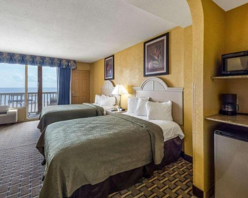 a hotel room with two beds and a balcony at Quality Inn & Suites on the Beach in Corpus Christi