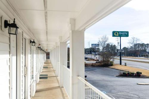 a white building with white columns and a street at Quality Inn in Carrollton