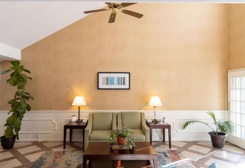 a living room with a ceiling fan and a couch at Quality Inn Carrollton Medical Center in Carrollton