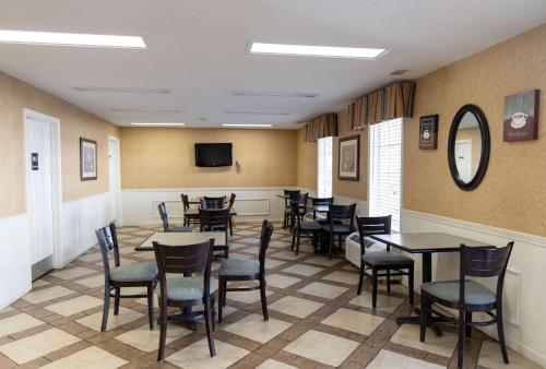 a dining room with tables and chairs and a tv at Quality Inn Carrollton Medical Center in Carrollton