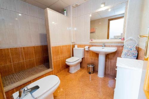 une salle de bain avec toilettes, lavabo et miroir dans l'établissement Adosado con vistas al Mar Menor y parking, à Santiago de la Ribera
