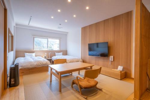 a bedroom with a bed and a desk and a table at Koyokaku in Ureshino