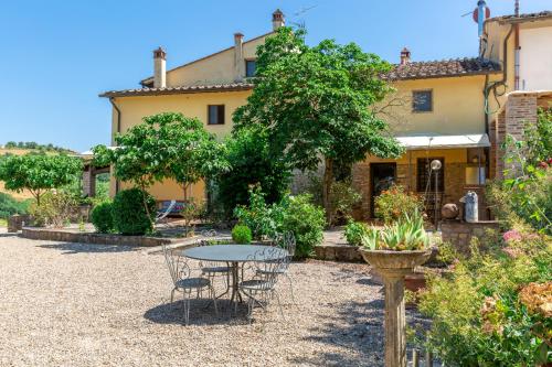 a garden with a table and chairs in front of a house at Agriturismo La Valle A Polvereto in Tavarnelle Val di Pesa