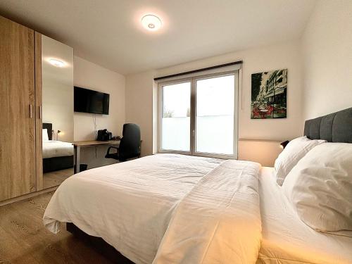 a bedroom with a large white bed with a window at Il Casolare in Beersel