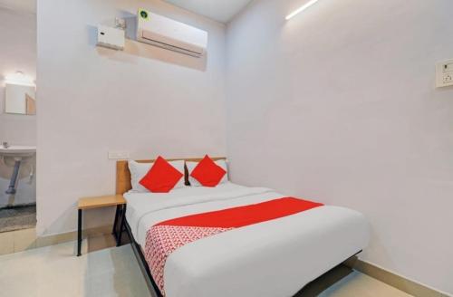 a bedroom with a bed with red pillows on it at Hotel I Plaza in Tallākulam