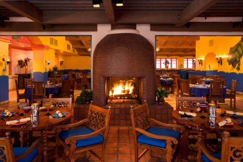 a restaurant with tables and a fireplace in the middle at La Quinta Resort & Club, Curio Collection in La Quinta