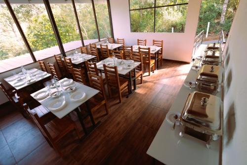 蒙納的住宿－Elenji Revive Resort，一间设有桌椅的餐厅,位于带窗户的房间内