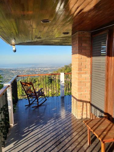 a porch with a bench and a view of the city at Tranquility Estate in Kingston