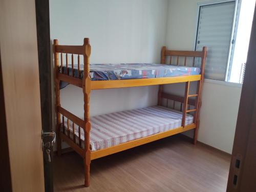 two bunk beds in a room with a window at Apartamento em Santa Barbara D'oeste 