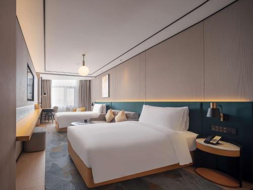 um quarto de hotel com uma cama grande e um sofá em Hilton Garden Inn Beijing Temple Of Heaven East Gate Station em Pequim
