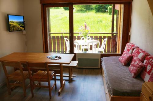 a living room with a table and a table and a dining room at Résidence Azureva La Clusaz les Aravis in La Clusaz