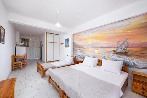 a bedroom with two beds and a painting on the wall at Zoe Seaside in Loutra Edipsou