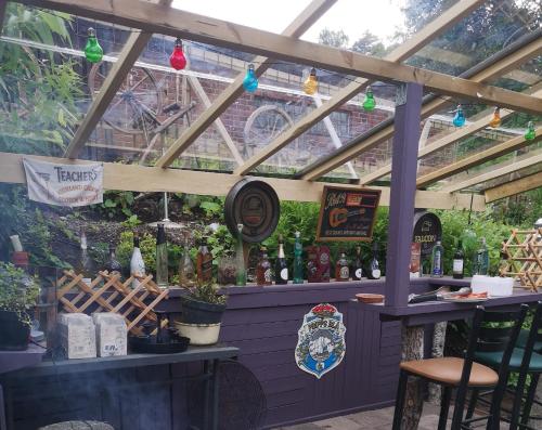 a bar under a pergola with bottles of alcohol at Stop at The Cross in Borås