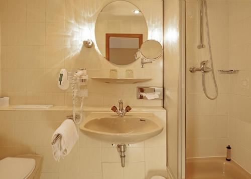 a bathroom with a sink and a shower with a mirror at Landhotel Goldener Acker in Morsbach