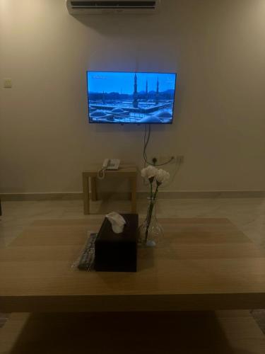 a living room with a flat screen tv on a wall at الساعه 60 الفندقيه in Dammam