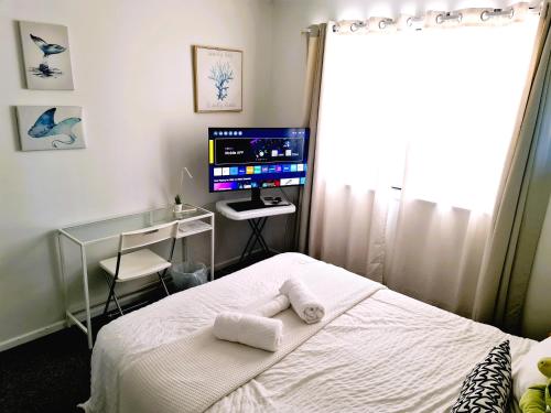 a bedroom with a bed and a desk and a television at Amazing City Location-Private Room in a Share House-2 Rooms available!! in Brisbane