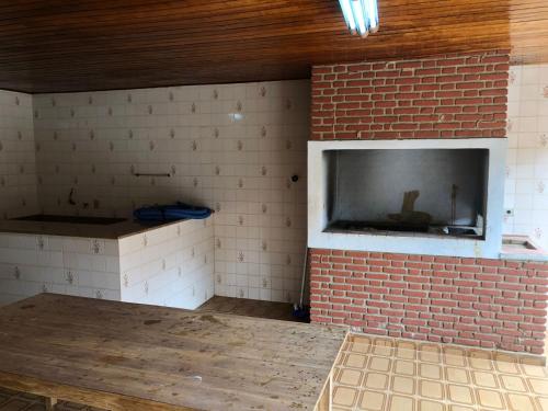 a room with a brick wall with a tv on it at Sitio in Pinhalzinho